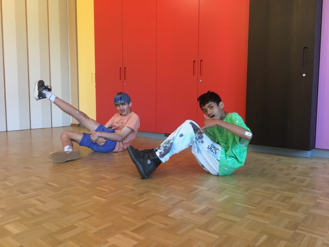 Zwei Hip-Hop tanzende Jugendliche in sitzender Haltung